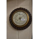 A circular oak rope twist framed wall barometer