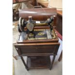 A wooden cased vintage Singer sewing machine on purpose-made work table