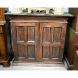 A stained hardwood hall cupboard with a pair of panelled doors enclosing shelves