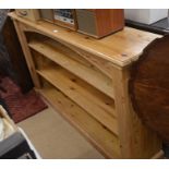 A stained pine open bookcase with two adjustable shelves between fluted pillars