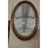 An Edwardian oval oak framed bevelled edge mirror