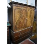 19th century mahogany linen press with panelled doors enclosing three slides over two short and