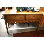 A Georgian style dresser base with two drawers, raised on chamfered square supports