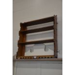 An open oak four tier wall hanging shelves with decorative frieze