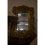 An Indian large rectangular mirror in gilt metal foliate frame