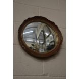 A circular red and gilt framed convex wall mirror