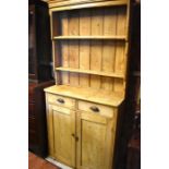 Early 20th narrow pine dresser, the plate rack with two shelves over drawers and panelled cupboard