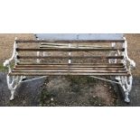 An antique Colebrookdale style cast iron and wood slat garden bench, the ends with dog head arm