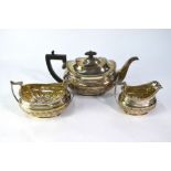 An Edwardian heavy quality silver three piece tea service in the Regency manner, with lobed half-