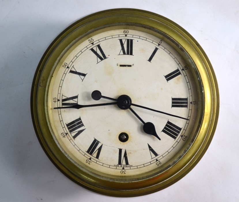 A vintage 8-day single fusee brass bulkhead clock, the white enamelled dial with Roman numerals,