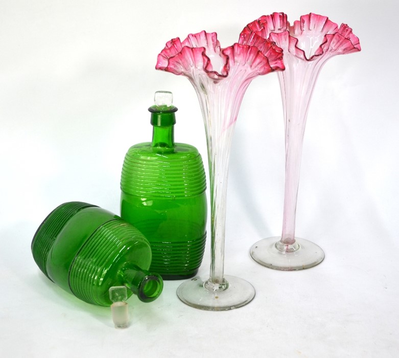 A pair of trumpet-shaped glass vases with cranberry rims, 30 cm, to/w a pair of green glass barrel-