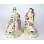 A pair of 19th century Berlin porcelain seated ladies with floral painted dresses and lacy