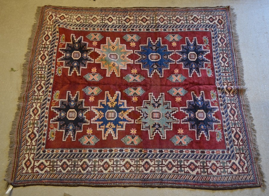 A Caucasian design Afghan carpet, the geometric star motifs on red-brown ground, 2.11 x 2.08 m