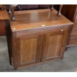 A hardwood side cabinet with a pair or panelled cupboard doors