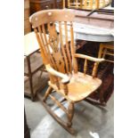 An elm seated high back rocking chair with turned supports and stretchers