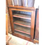 A mahogany pier cabinet/bookcase with a  single glazed door enclosing three shelves raised on a