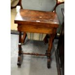 A Victorian rosewood games table with hinged rotating and fitted drawer on twin turned column