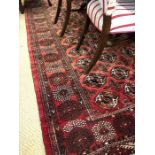 A Turkoman red ground carpet with repeating gul design within guarded border, 300 x 215 cm