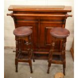 A panelled mahogany free standing bar with turned rails to/w a pair of oak framed bar stools