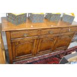 A good quality oak dresser base with three drawers over arch panelled cupboard doors