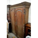 A hardwood shallow hall cupboard with full length panelled doors enclosing shelved interior