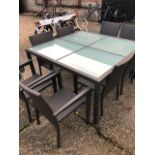 A substantial glass panelled rattan weather weave all-weather terrace table to/with a matching set