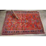 A Persian Hamadan red ground rug with vase and flowers design within a narrow navy border