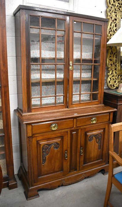 Edwardian mahogany chiffonier bookcase with a pair of glazed doors over two drawers and carved