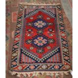 A small Turkish geometric rug with navy medallions on red ground within a kelim ended multi border