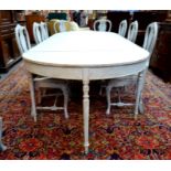 A pale grey chalk painted Swedish Gustavian style double d-end dining table raised on six turned