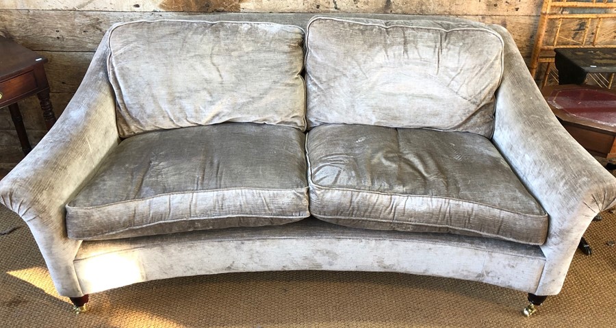 A silver-grey dralon upholstered three seater settee of concave form, raised on turned front legs to