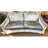 A silver-grey dralon upholstered three seater settee of concave form, raised on turned front legs to