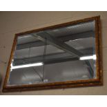 A rectangular decorative gilt framed bevelled edge mirror