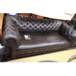 A dark brown leather chesterfield three seater sofa