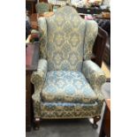 A Georgian style mahogany framed wingback arm chair with green damask upholstery, cabriole front