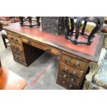 Early 20th century large oak desk with tooled red leather top over fitted slides and nine drawers