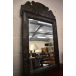 A large ebonised bevelled edge wall mirror painted with Oriental figures, pagoda etc