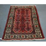 A Persian Hamadan rug with stylised design on red ground and guarded ivory border 160 x 107 ccm