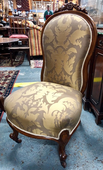 A Victorian walnut spoon-back nursing chair with upholstered seat and back, on cabriole supports