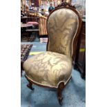A Victorian walnut spoon-back nursing chair with upholstered seat and back, on cabriole supports