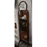 A mahogany cheval mirror with shaped top