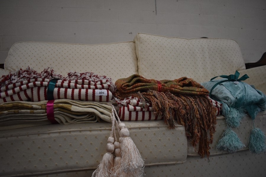 A pair of red-white striped cotton throws, a tapestry style throw with fringing and two other