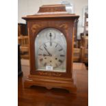 An inlaid mahogany triple train mantel clock