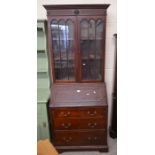 A mahogany bureau bookcase with glazed doors and a fall front panel enclosing fitted interior over