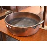 A large antique copper preserve pan with twin brass handles