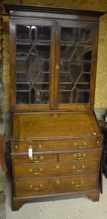 A 19th century oak bureau bookcase with glazed doors and fall front panel with fitted interior