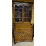 A 19th century oak bureau bookcase with glazed doors and fall front panel with fitted interior