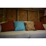 A pair of terracotta cushions, a tapestry effect tasselled cushion and a turquoise/white cushion