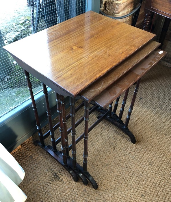 Nest of three mahogany occasional tables raised on slender turned supports