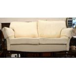 A Howard style two seater sofa with diamond patterned upholstery raised on turned oak legs with